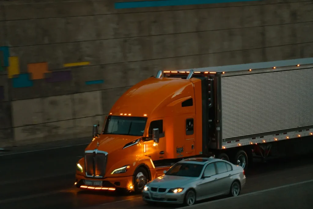 Semi-truck driving next to a car