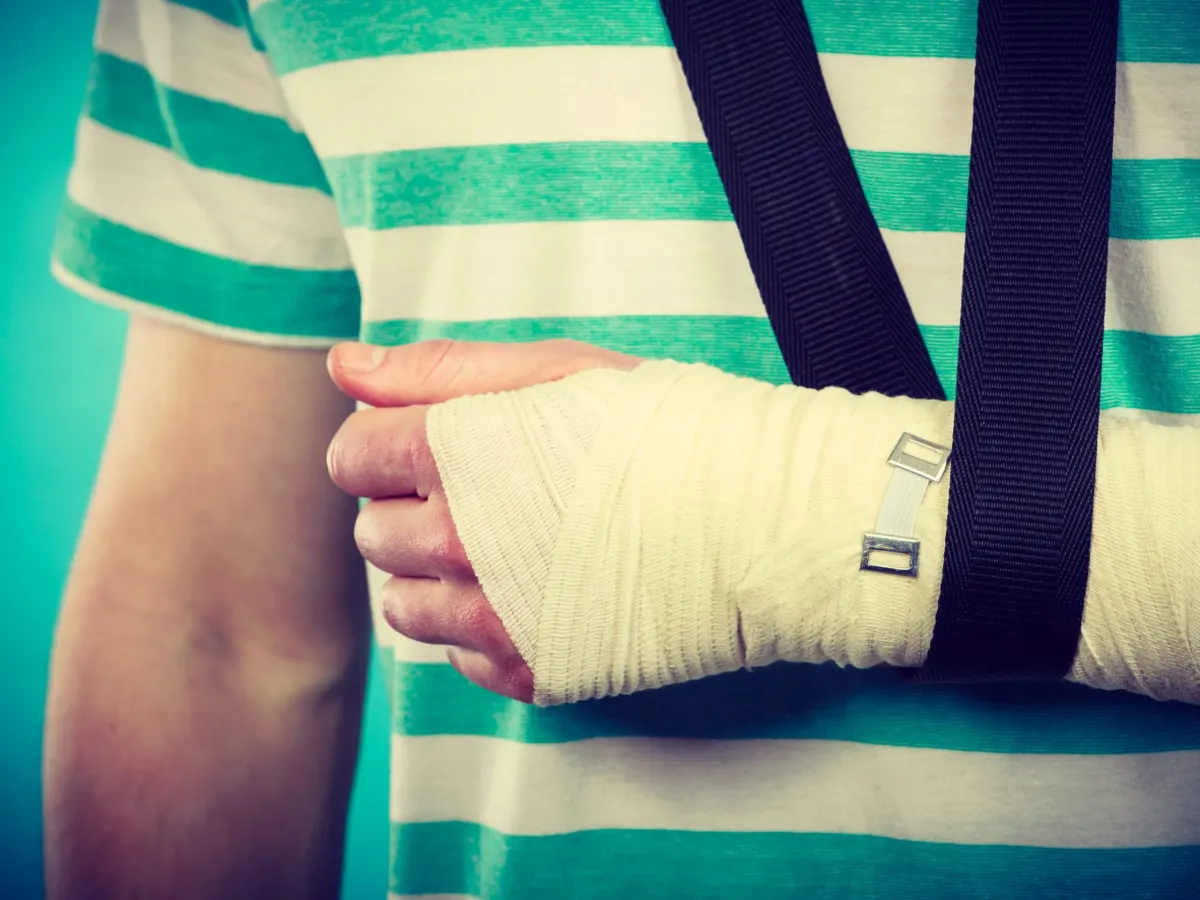 Person with an arm cast and sling after an injury